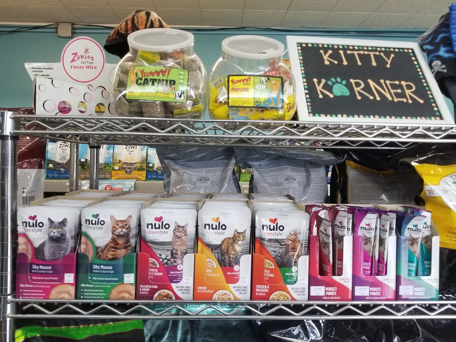Pet store shelf with Nulo cat food, catnip toys, and Kitty Korner sign