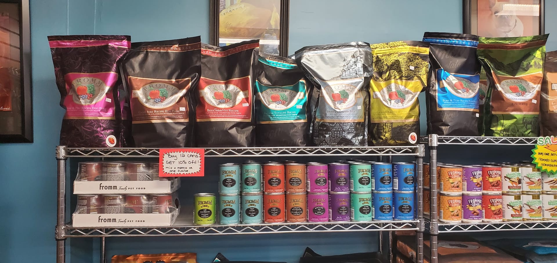 Shelves stocked with Fromm dry dog food bags and canned wet food varieties