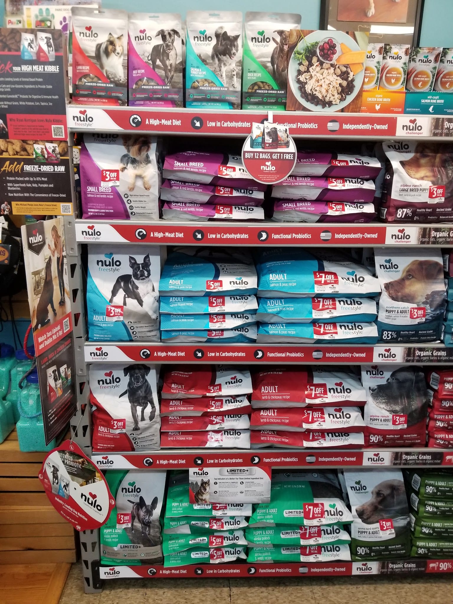 Nulo Freestyle dog food bags stacked on retail shelves with sale tags